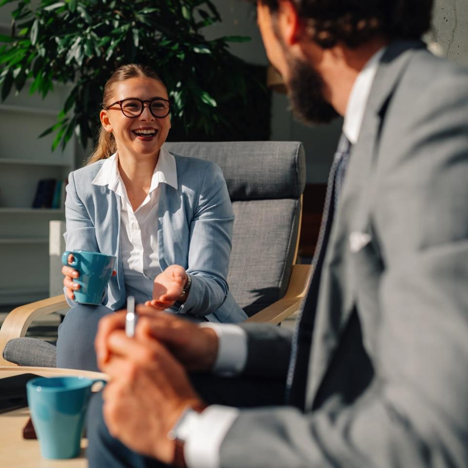 Frau und Mann in Businesskleidung bei einer Tasse Kaffee im Gespräch