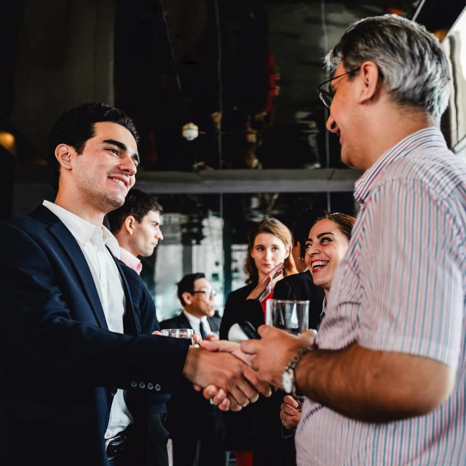 Eine Gruppe von Businessleuten im Gespräch, sich die Hände schüttelnd